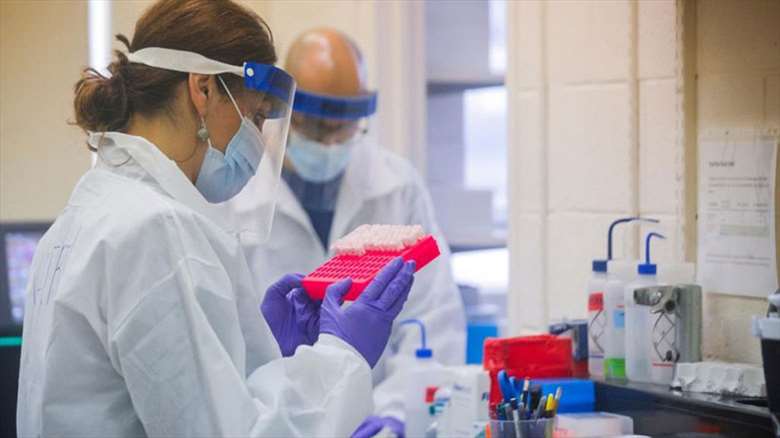 Medical professionals examine test tubes. (Photo: Archive)